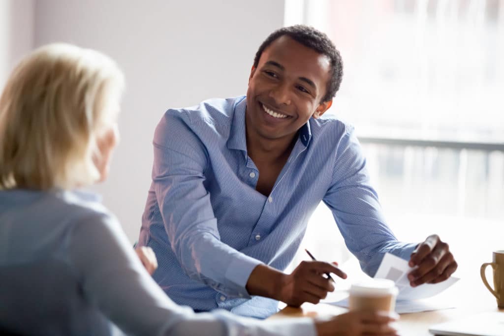 Smiling business leader talking with colleague in meeting